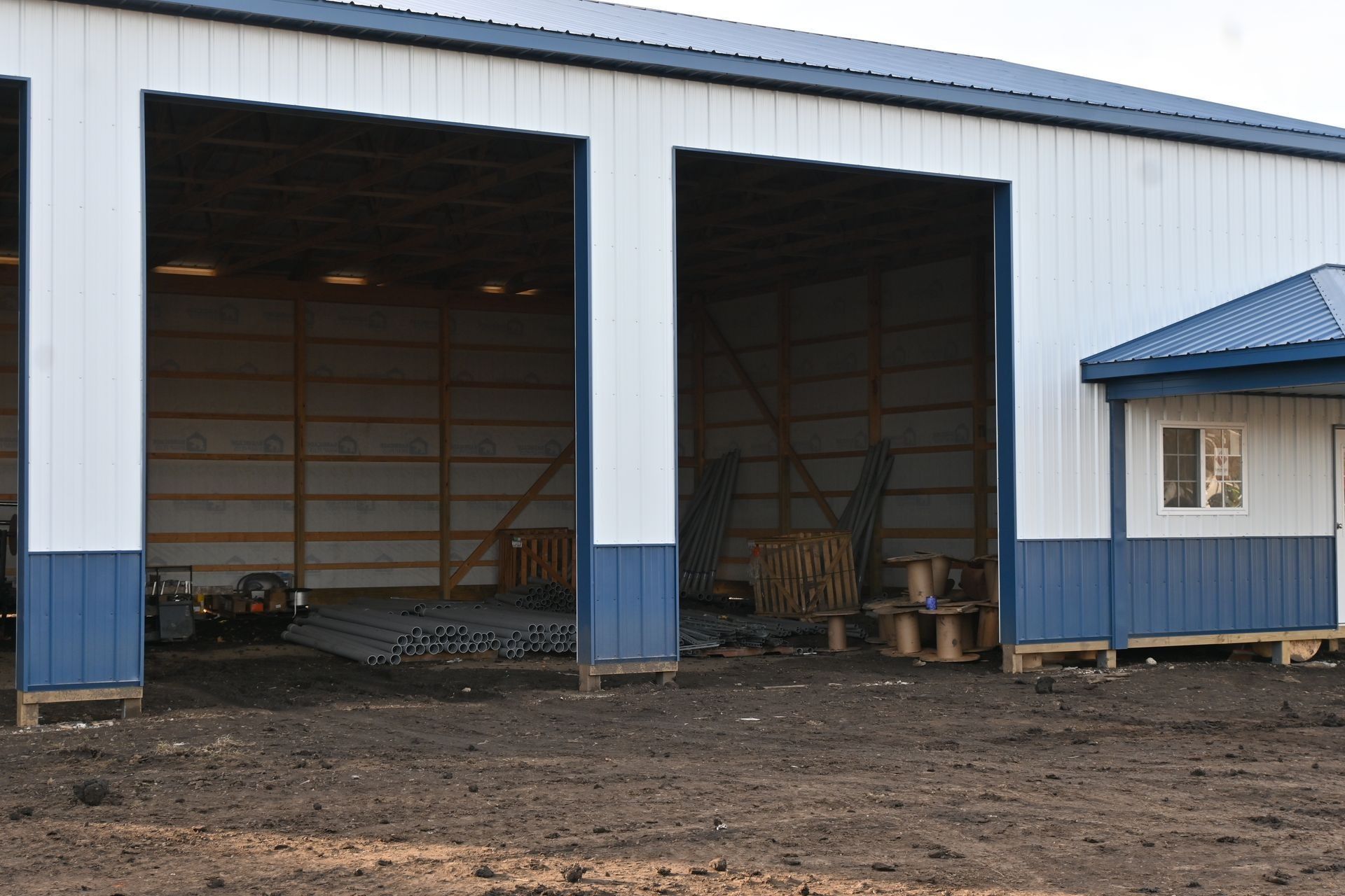 Open-front post-frame building with blue wainscot